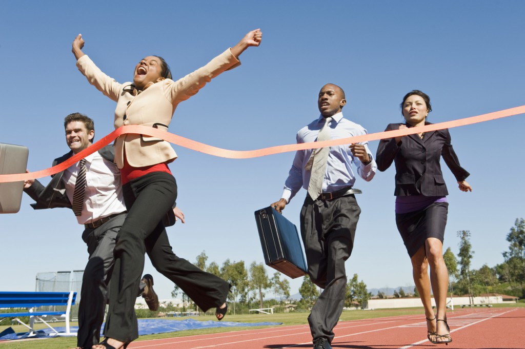 Woman Crossing The Finish Line With Colleagues Running