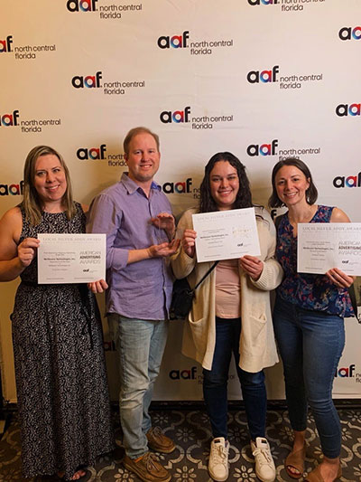 Team members accept awards at the 2023 Addy Awards in Gainesville.